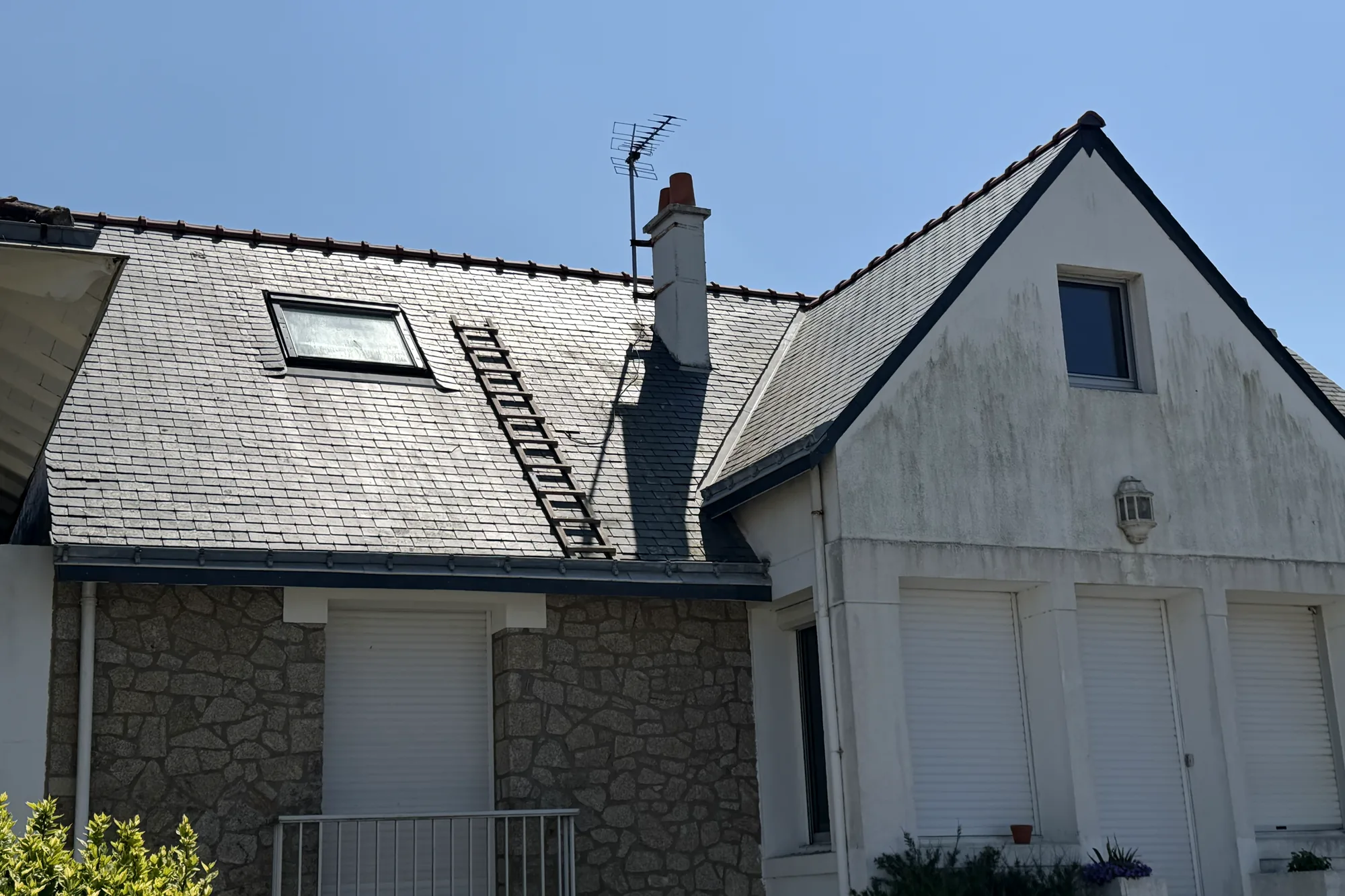 Maison ancienne en pierre couverte d’ardoise, lucarne et fenêtre de toit, après intervention de l’entreprise