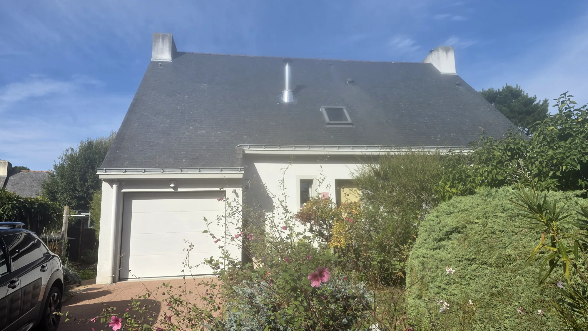 Maison couverte d’ardoise, toiture terminée, vue depuis le jardin