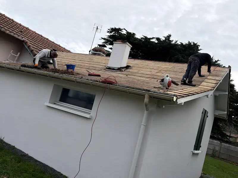 Dépose des tuiles d’une toiture ancienne, à deux, avant réparation